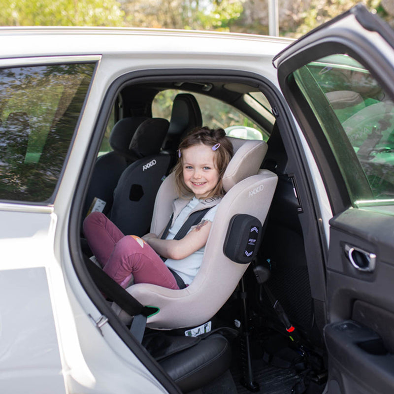 Child sitting strapped in to rear-facing axkid minikid 4 ready for a car journey.